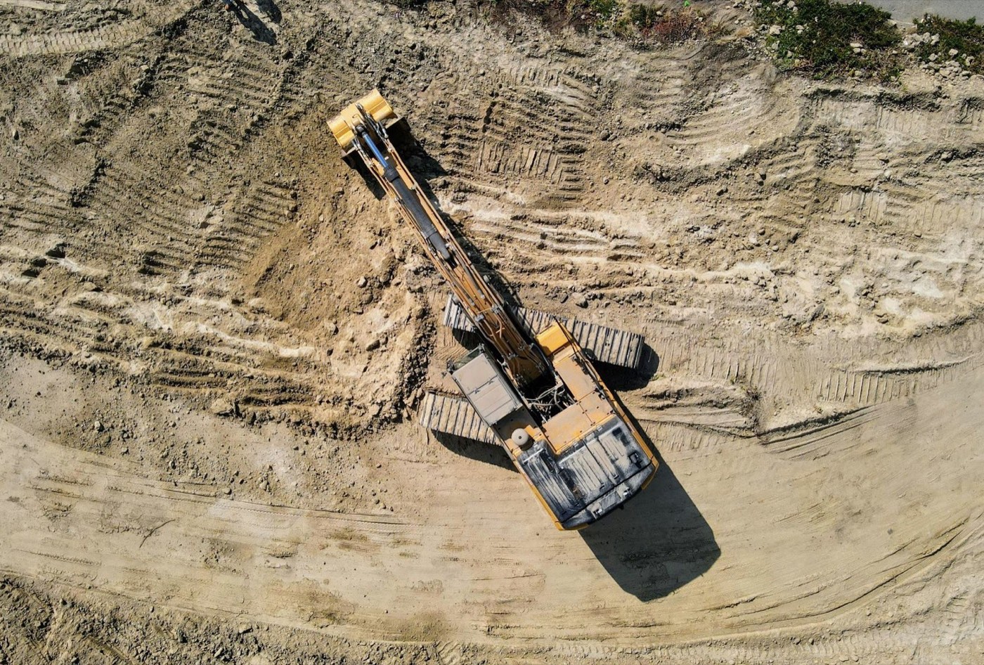 Excavator cutting a building pad, seen from above
