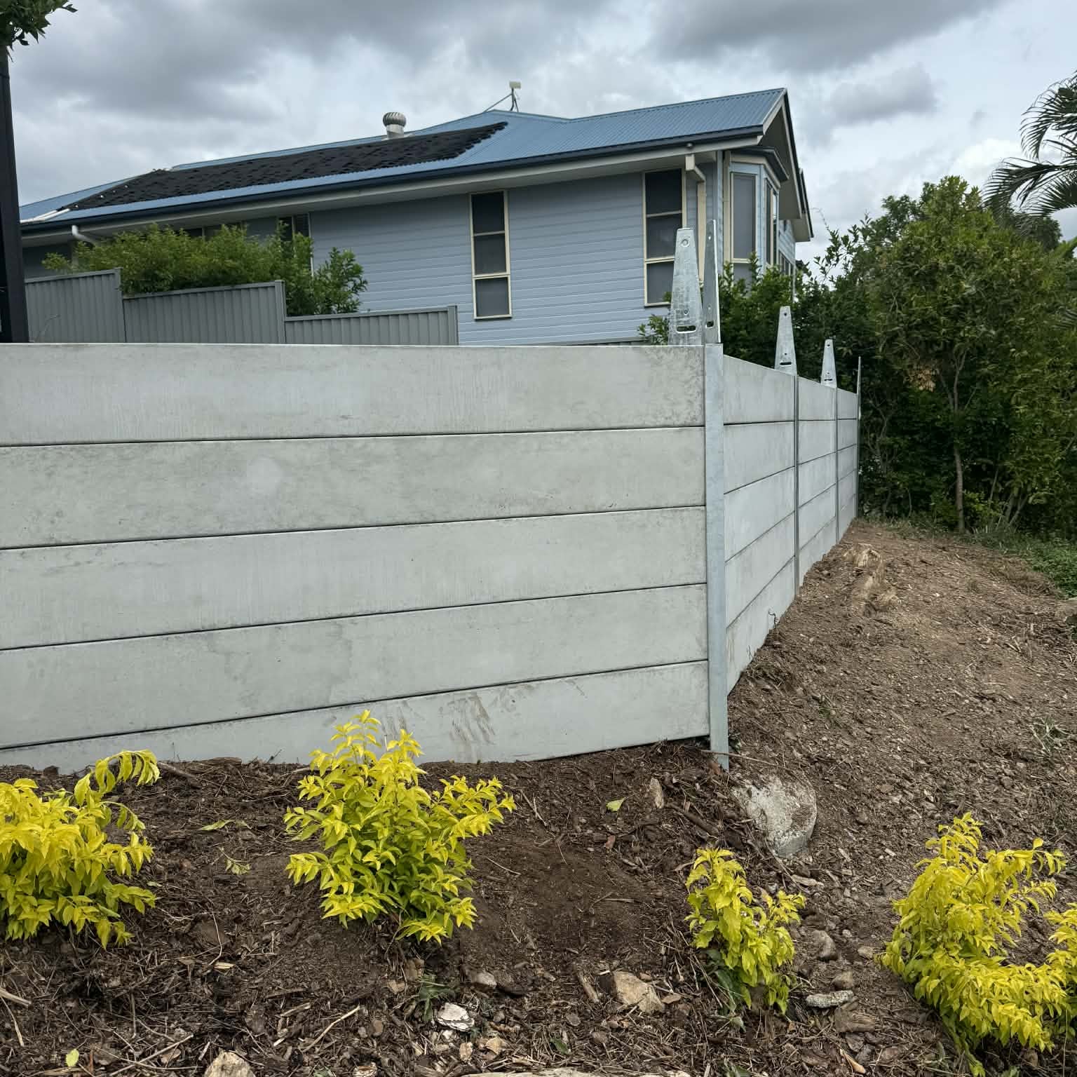 Concrete sleeper retaining wall with steel posts