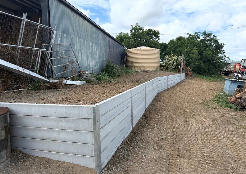New concrete sleeper retaining wall and cleared, level ground beside the shed